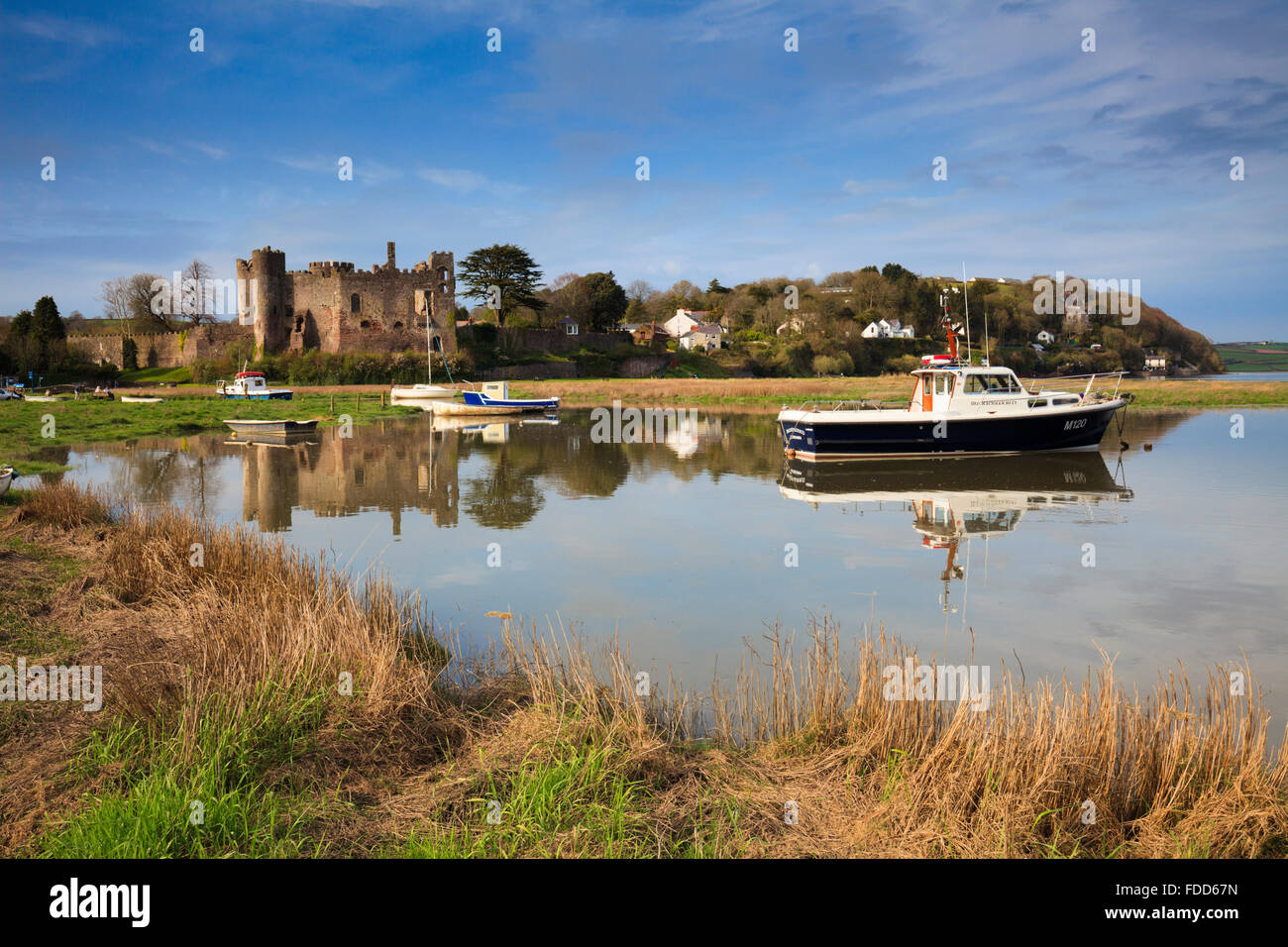 The medieval castle at Laugharne in Carmathernshire, catptured at high tide on a sunny evening in mid April. Stock Photo