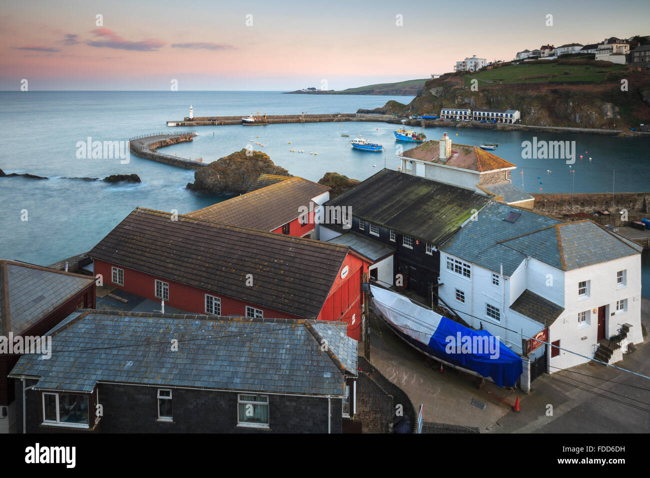 The outer harbour at Mevagissey in Cornwall captured at sunset. Stock Photo