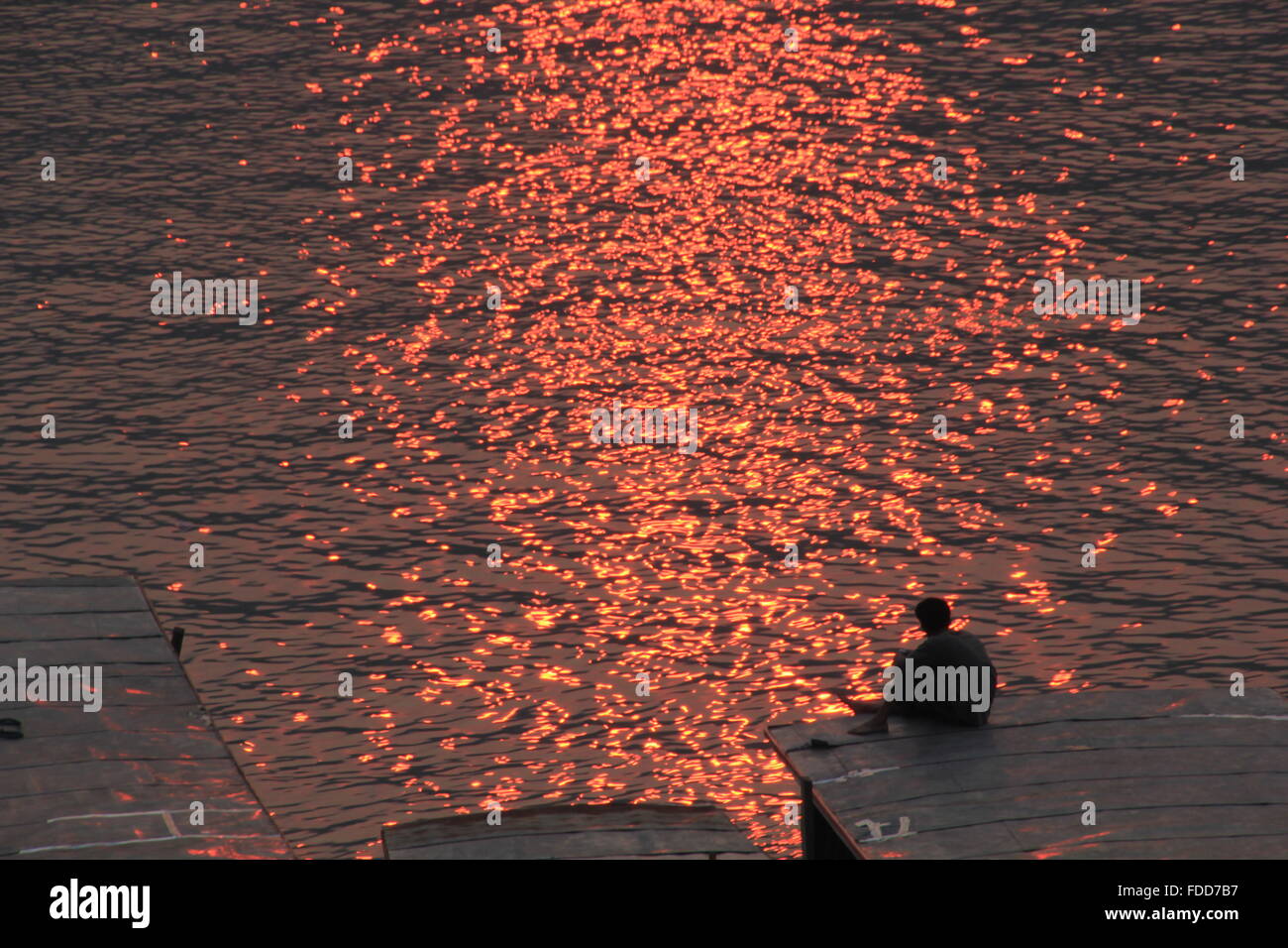 man sitting on a boat and watches the sunset Stock Photo - Alamy