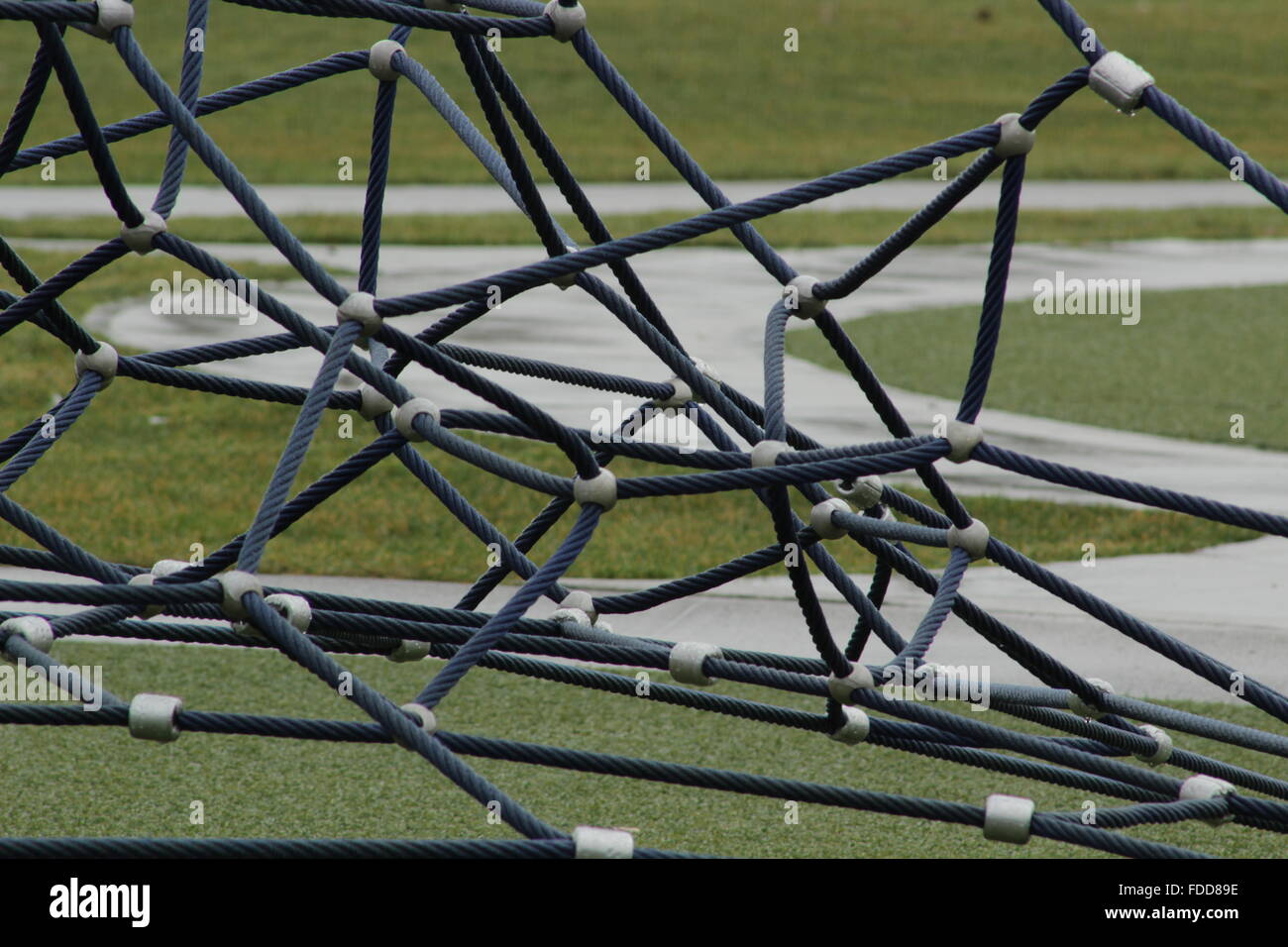 Playground equipment webbing with path in the background Stock Photo ...
