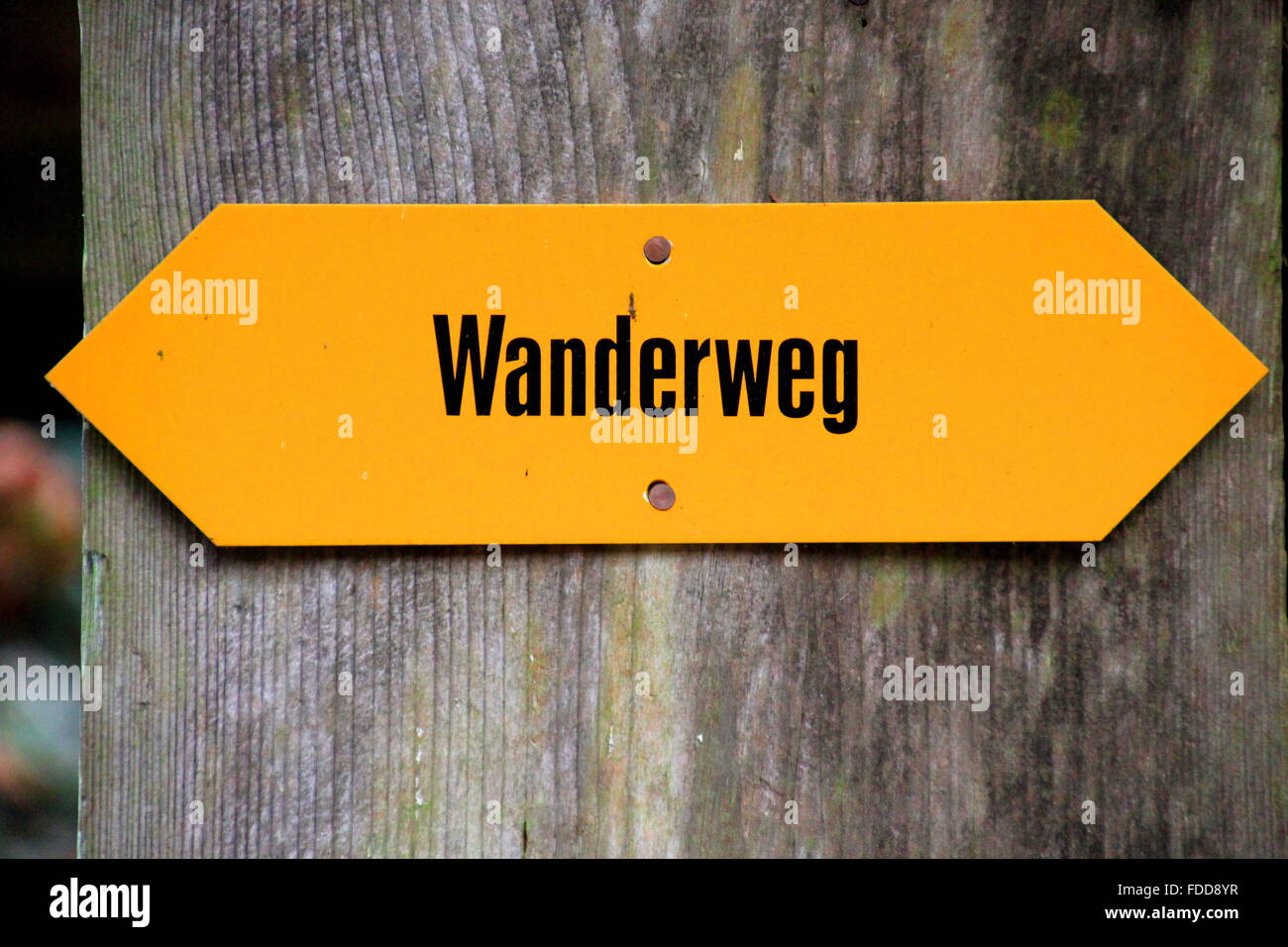 Wanderweg written on a yellow direction sign Stock Photo