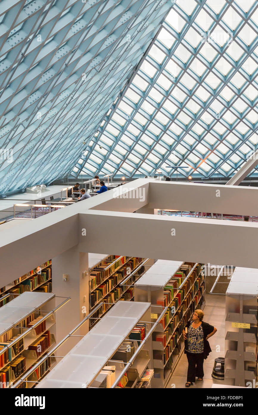 Woman walking in book stacks of the modern Seattle Central Library, designed by architects Rem Koolhaas and Joshua Prince-Ramus Stock Photo