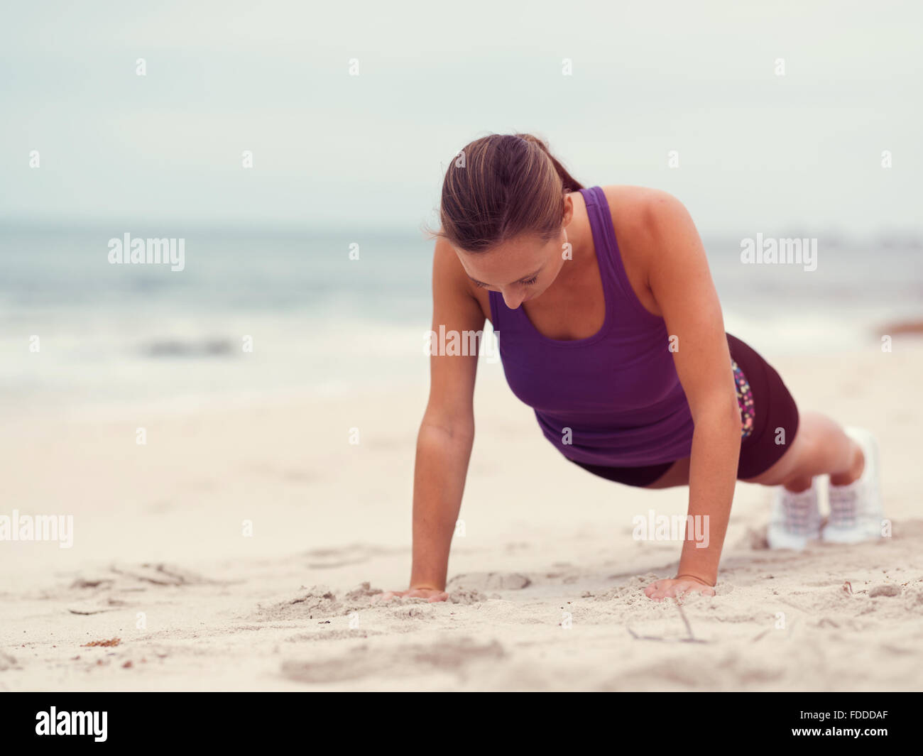 Sporty young woman doing push ups on the sea coast Stock Photo - Alamy