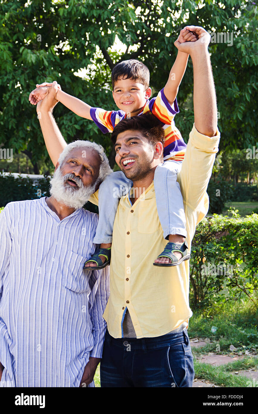 3 People GrandFather son and Grandson Park Carrying On Shoulders fun Stock Photo