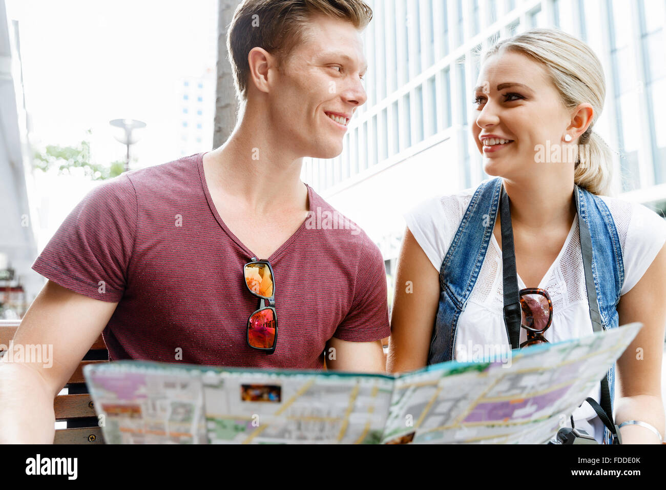 Happy young couple as tourists with a map Stock Photo - Alamy