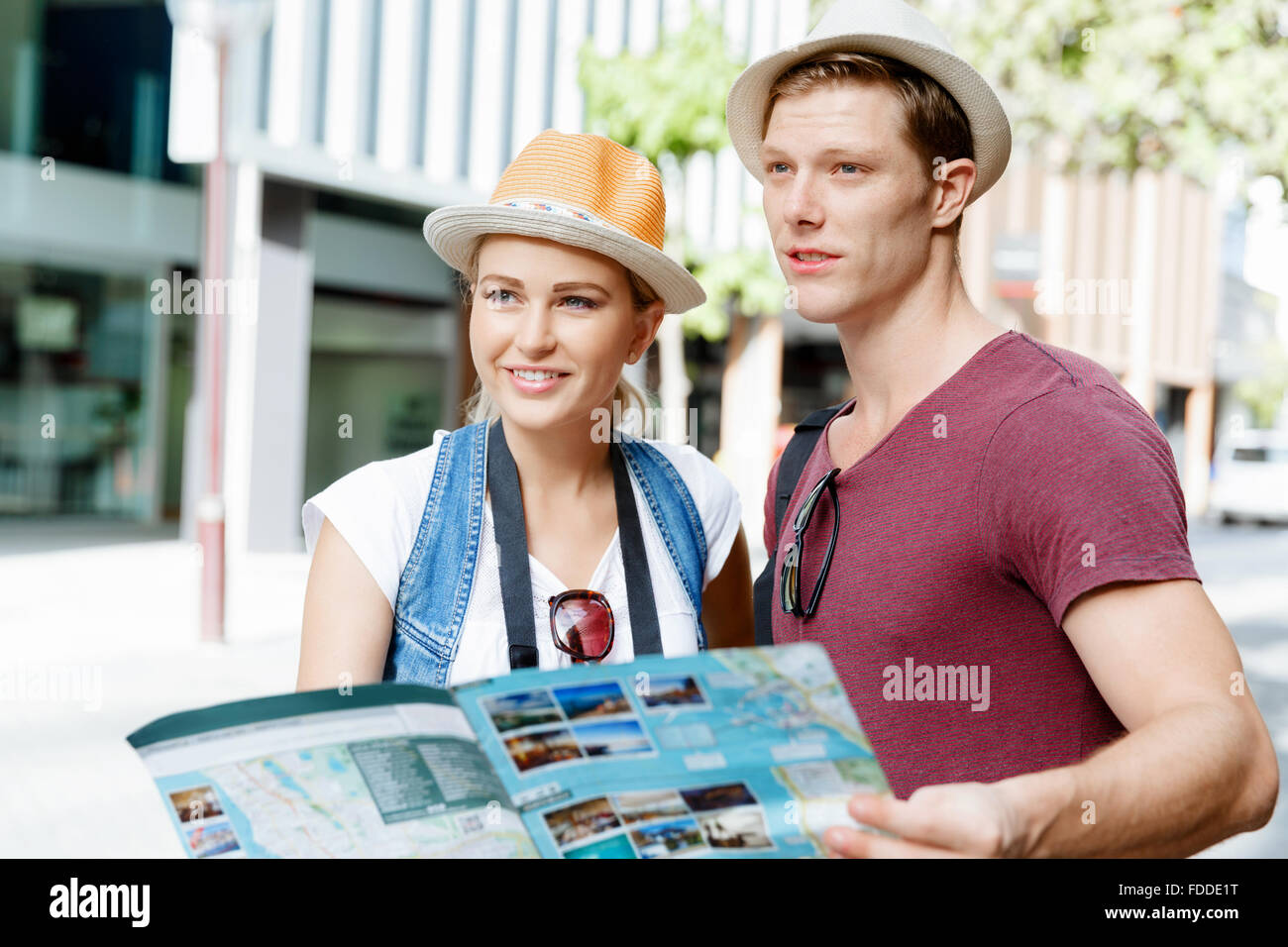 Happy young couple as tourists with a map Stock Photo - Alamy