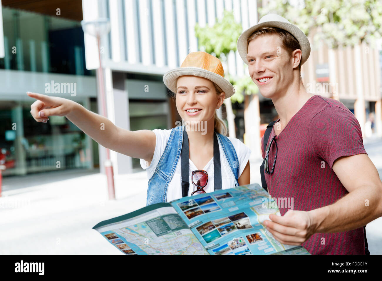 Happy young couple as tourists with a map Stock Photo - Alamy