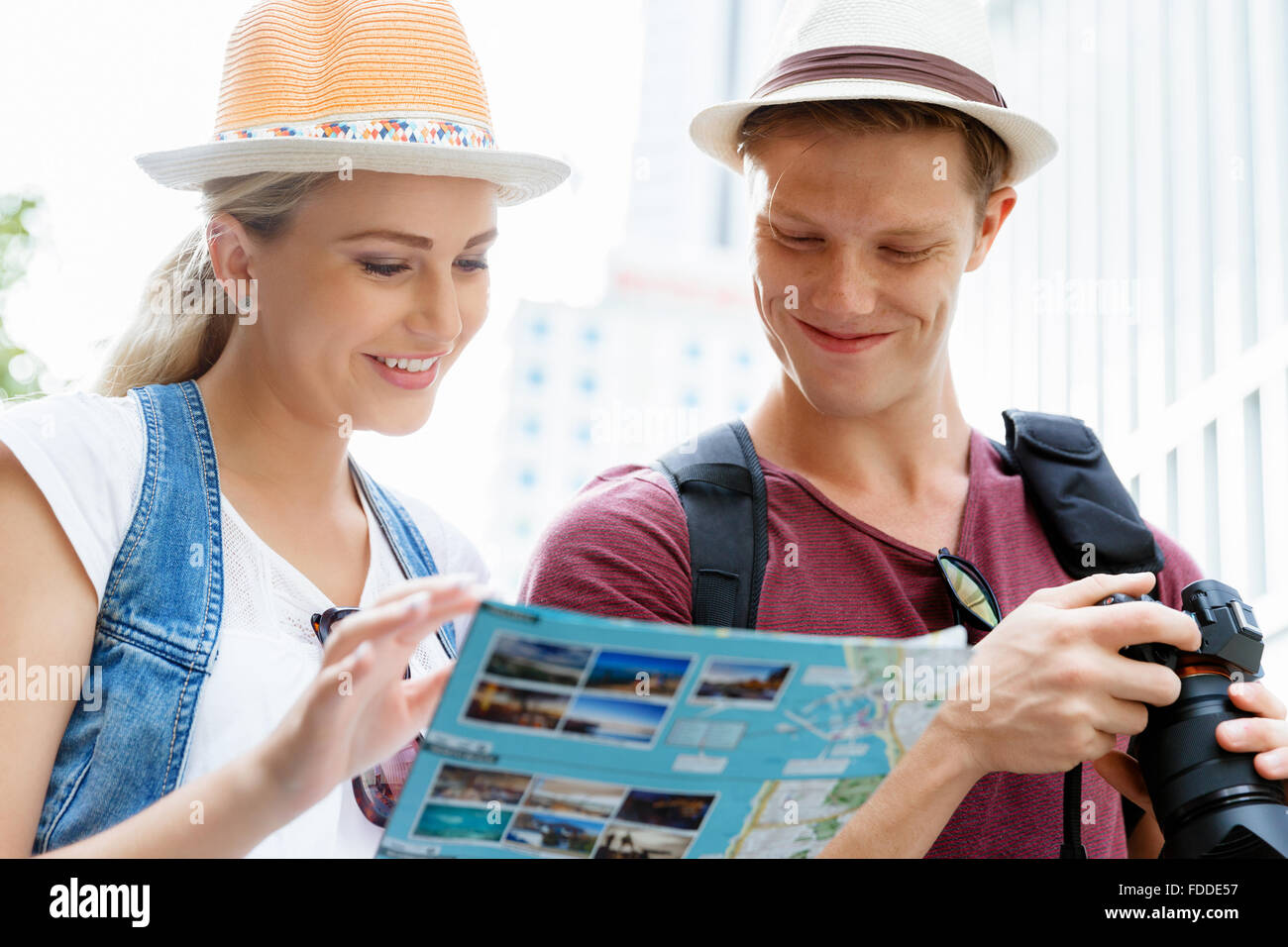 Happy young couple as tourists with a map Stock Photo - Alamy