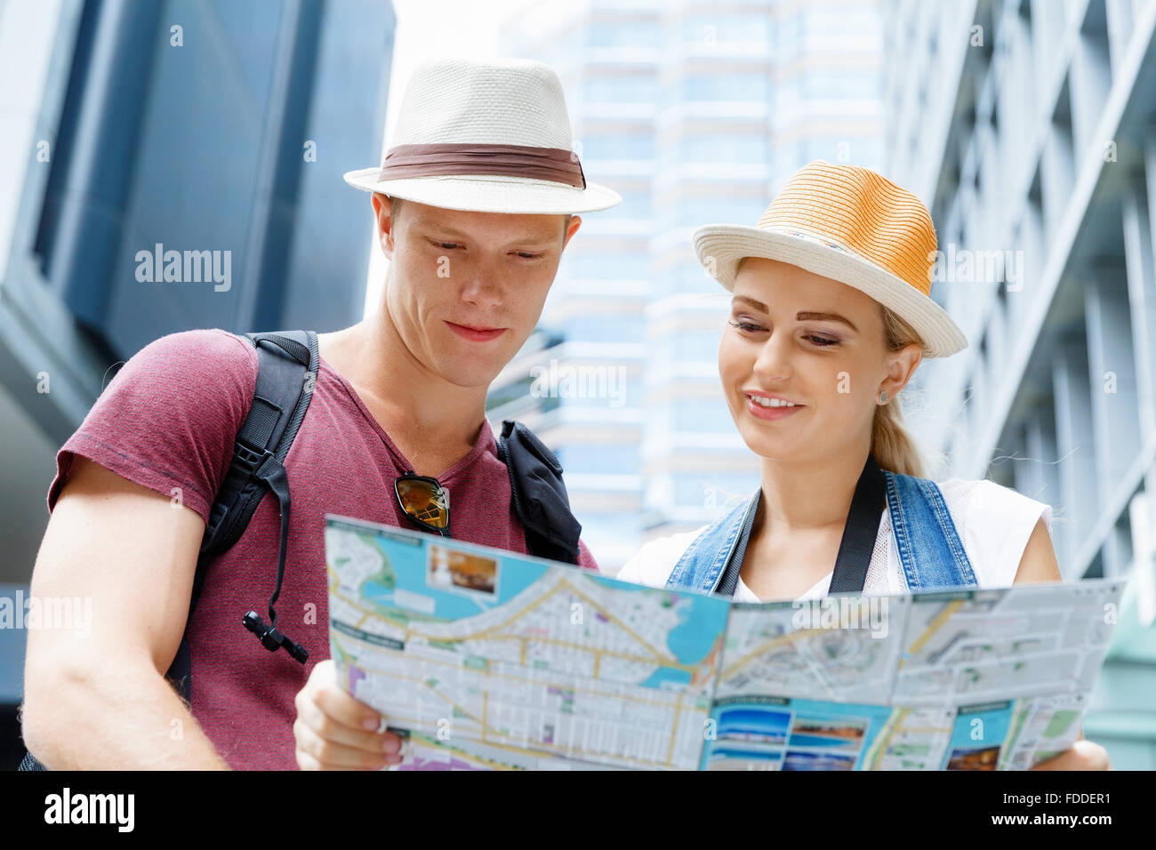 Happy young couple as tourists with a map Stock Photo - Alamy