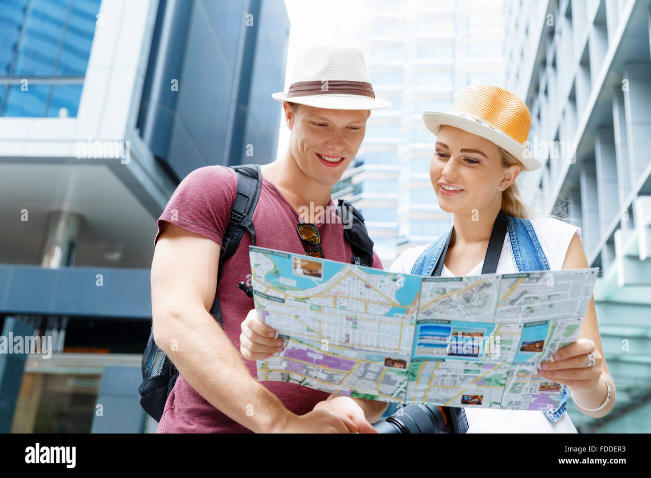 Happy young couple as tourists with a map Stock Photo - Alamy
