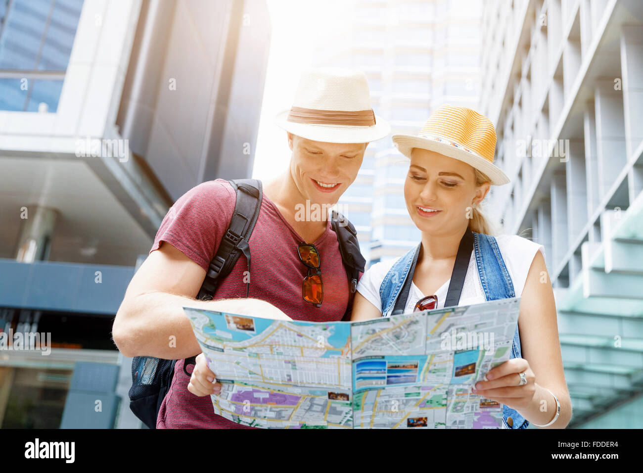 Happy young couple as tourists with a map Stock Photo - Alamy