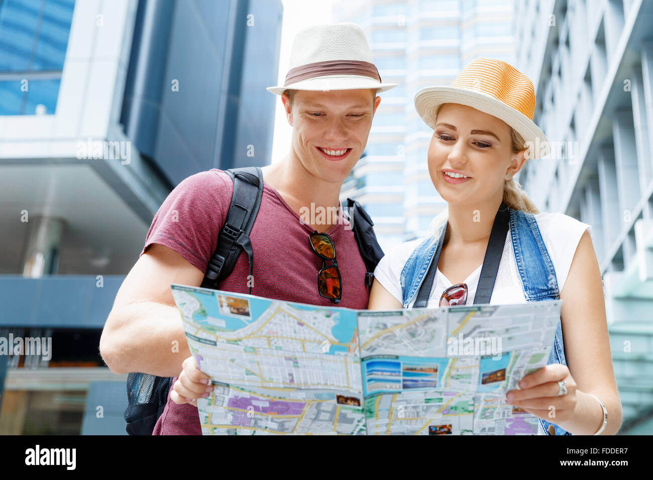 Happy young couple as tourists with a map Stock Photo - Alamy
