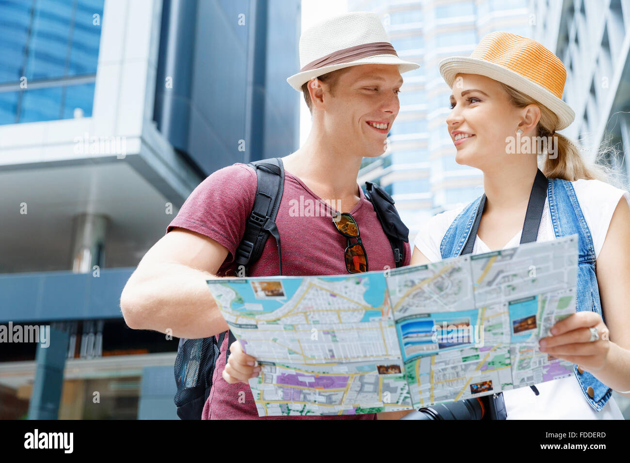 Happy young couple as tourists with a map Stock Photo - Alamy