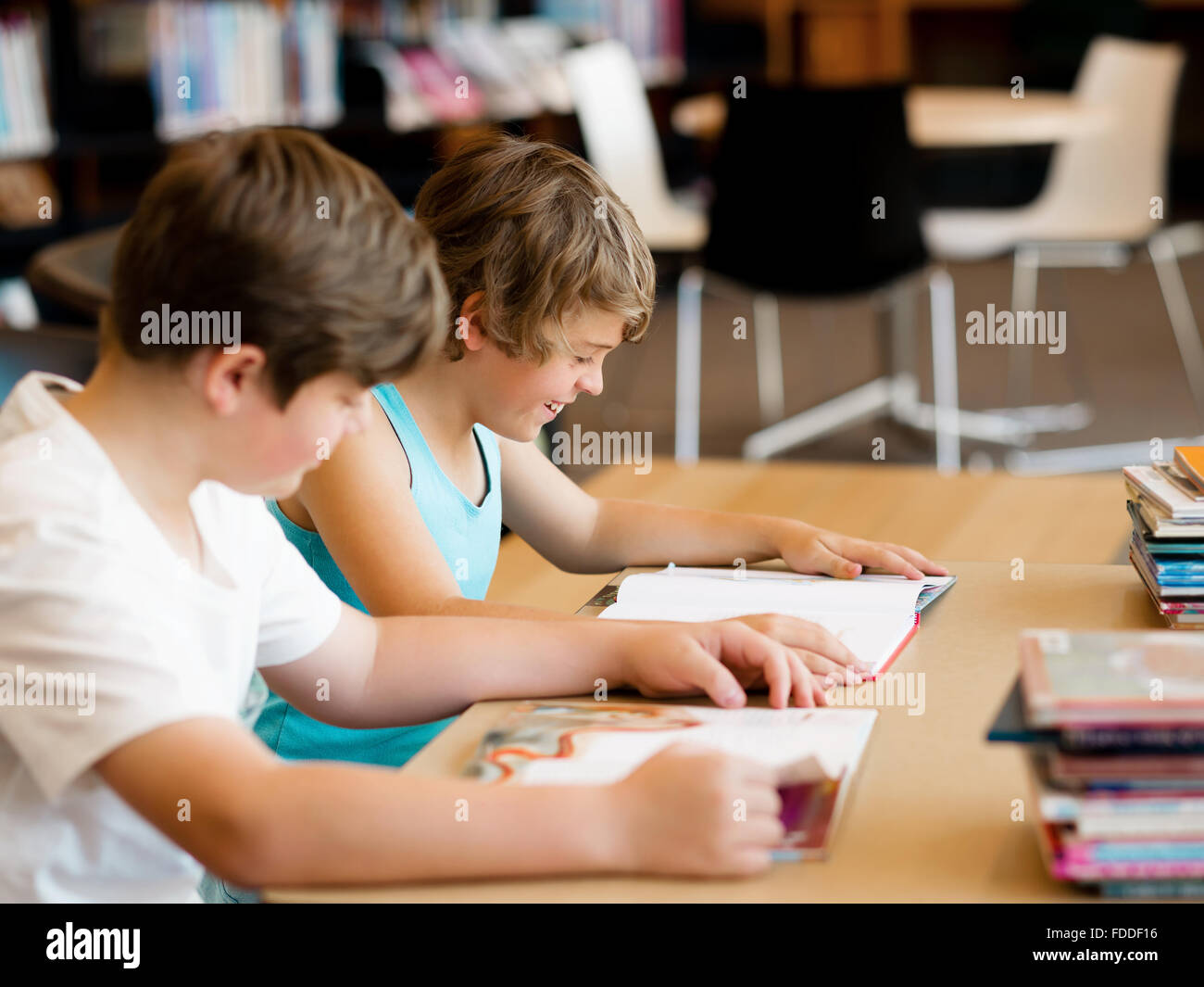 Two boys in library with books Stock Photo - Alamy