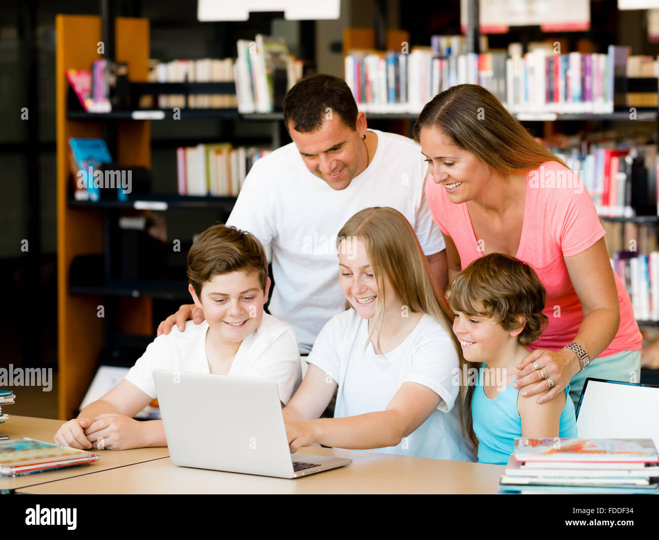 Family in library with books Stock Photo - Alamy