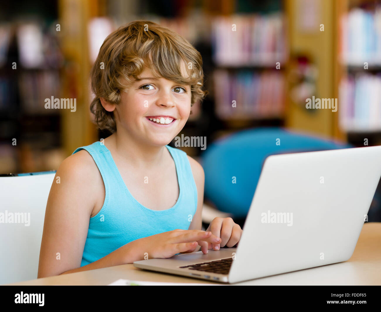 Little boy with laptop in library Stock Photo - Alamy