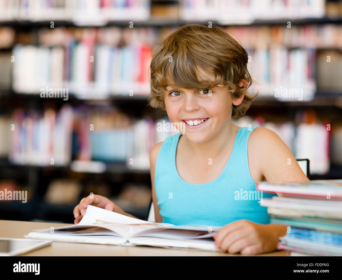 Boy in library with books Stock Photo - Alamy