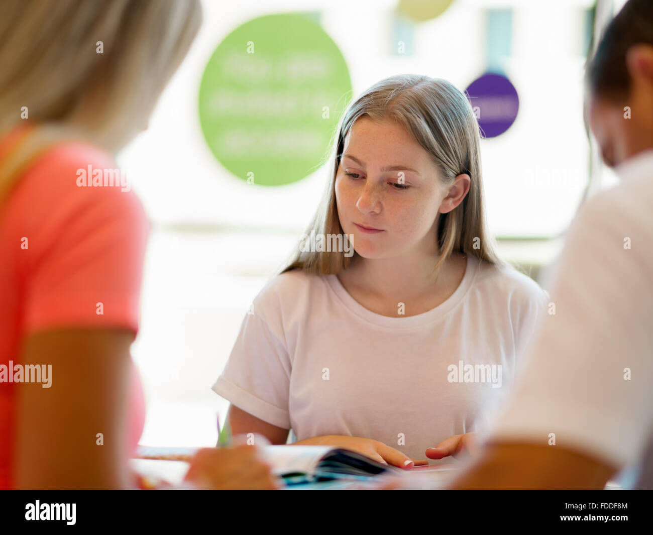 Teenage girl with books studying in library Stock Photo - Alamy