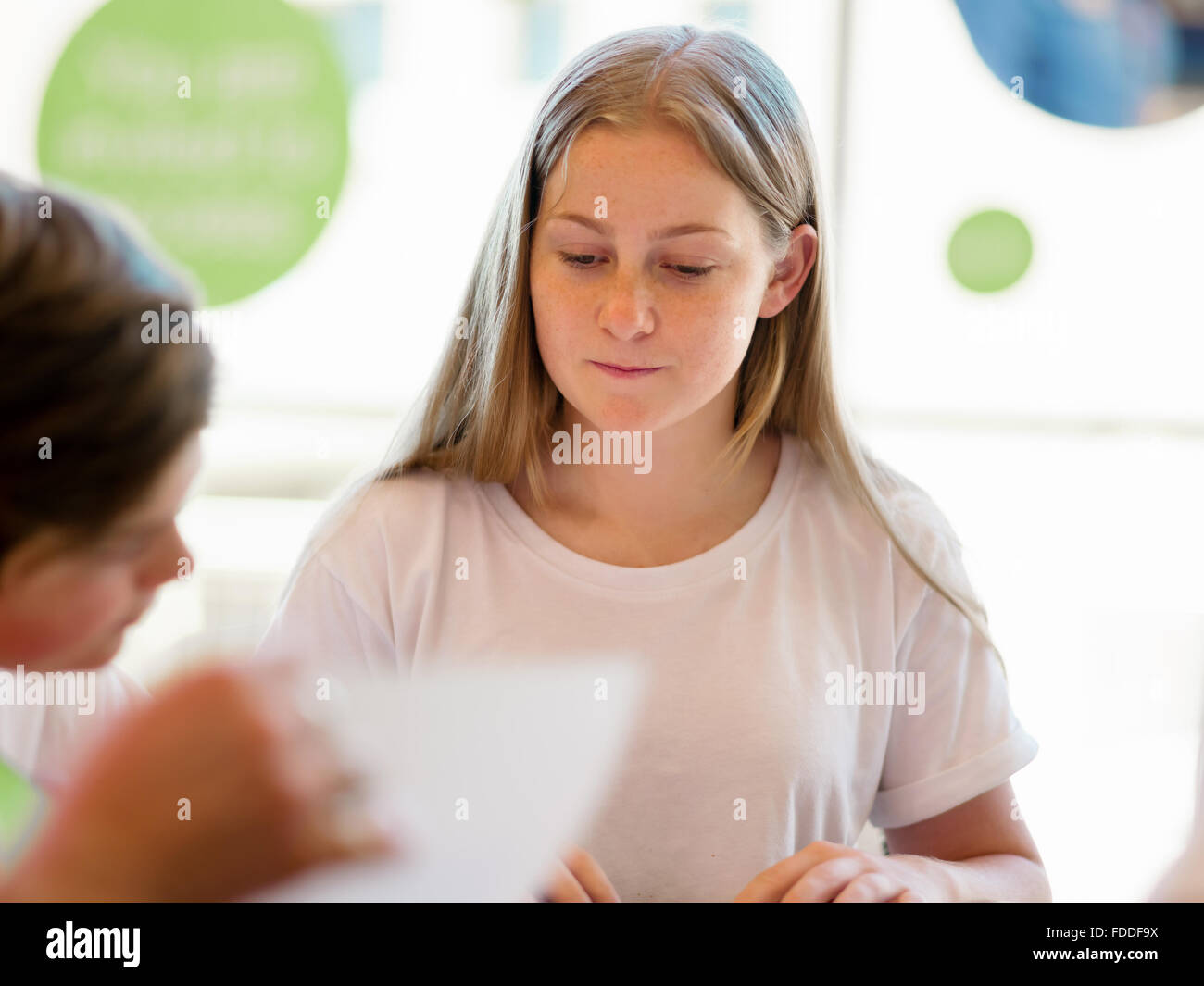 Teenage girl with books studying in library Stock Photo - Alamy