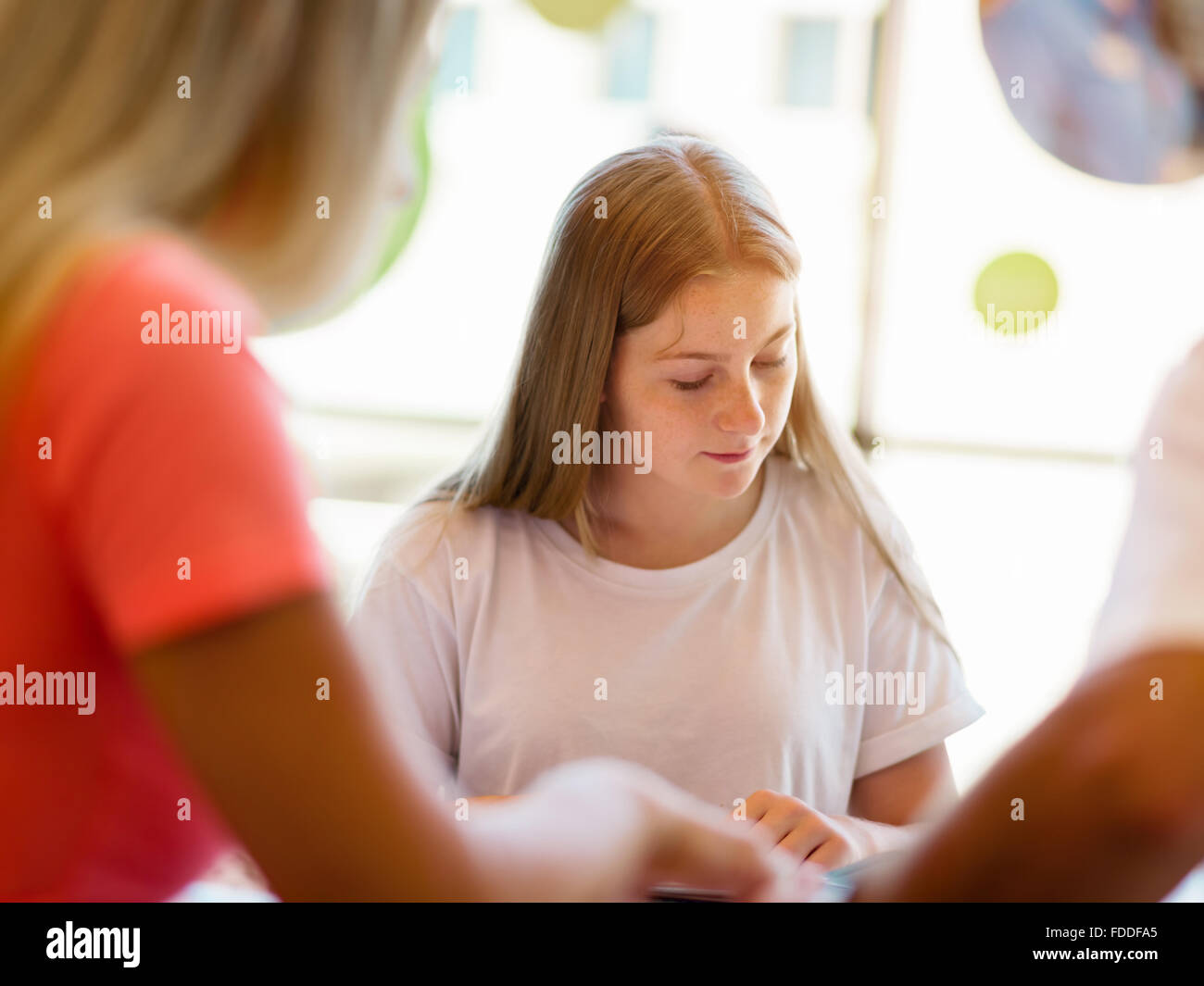Teenage girl with books studying in library Stock Photo - Alamy