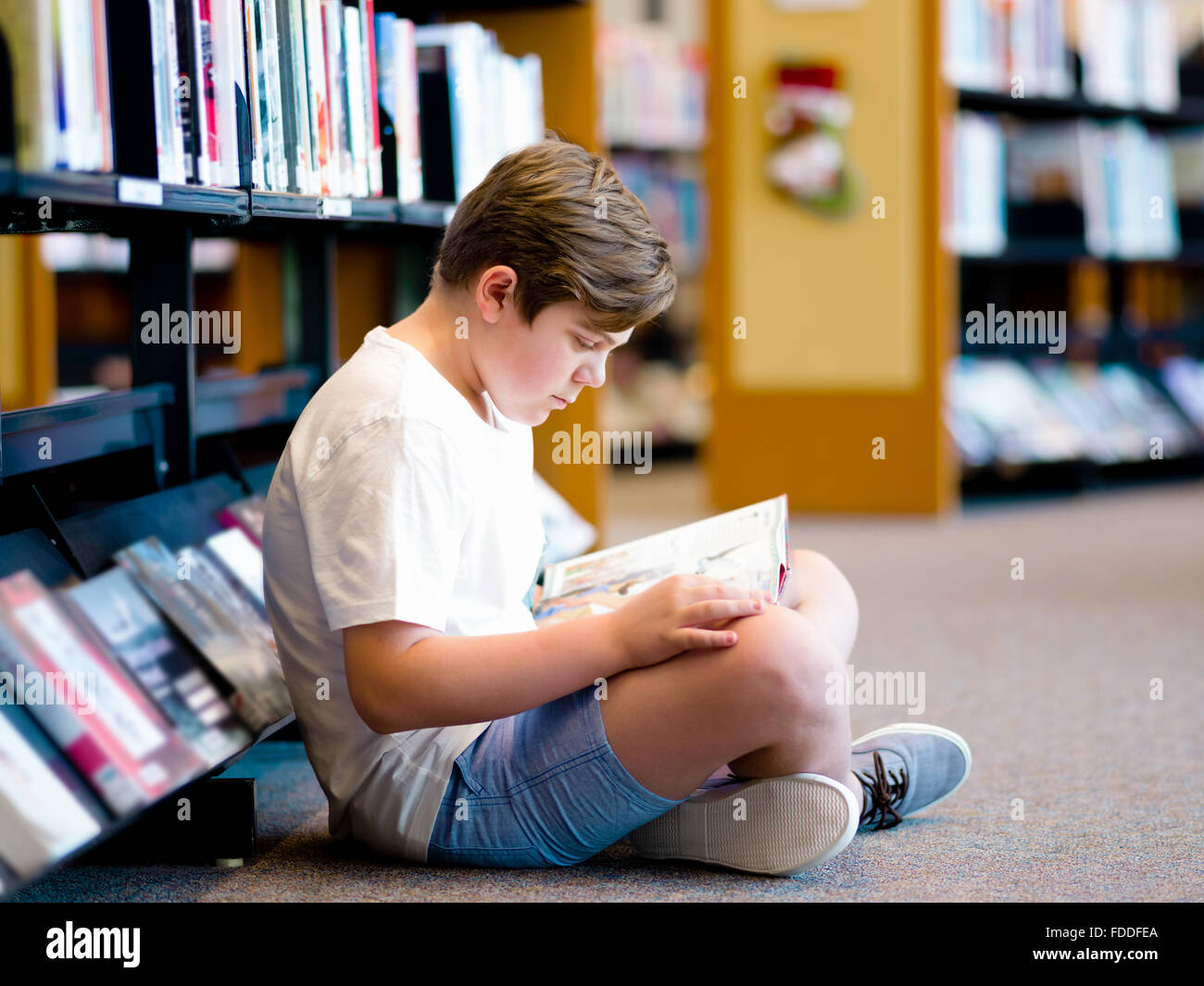 Boy in library with books Stock Photo - Alamy