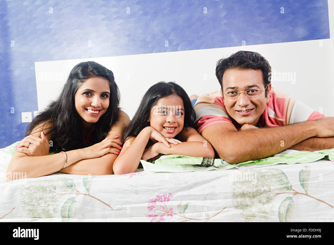 3 People Parents and Kid Daughter Bedroom Lying Down Relaxation Stock Photo