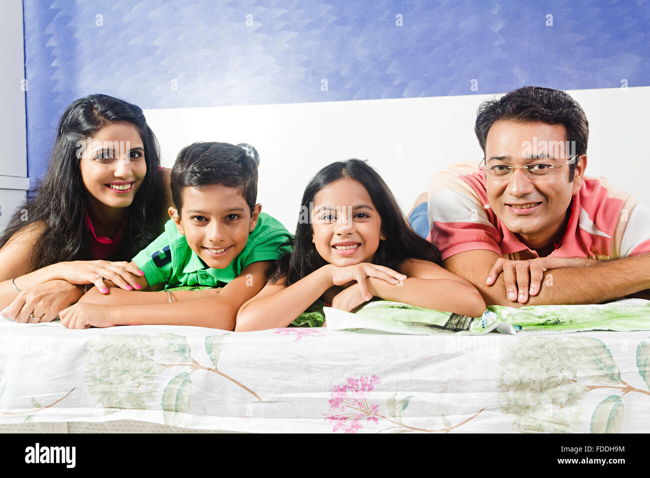 4 People Parents and Kid Bedroom Lying Down Relaxation Stock Photo