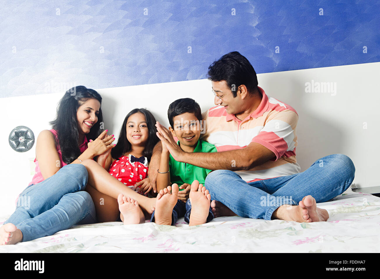 4 People Parents and Kid Bedroom Sitting Relaxation Stock Photo