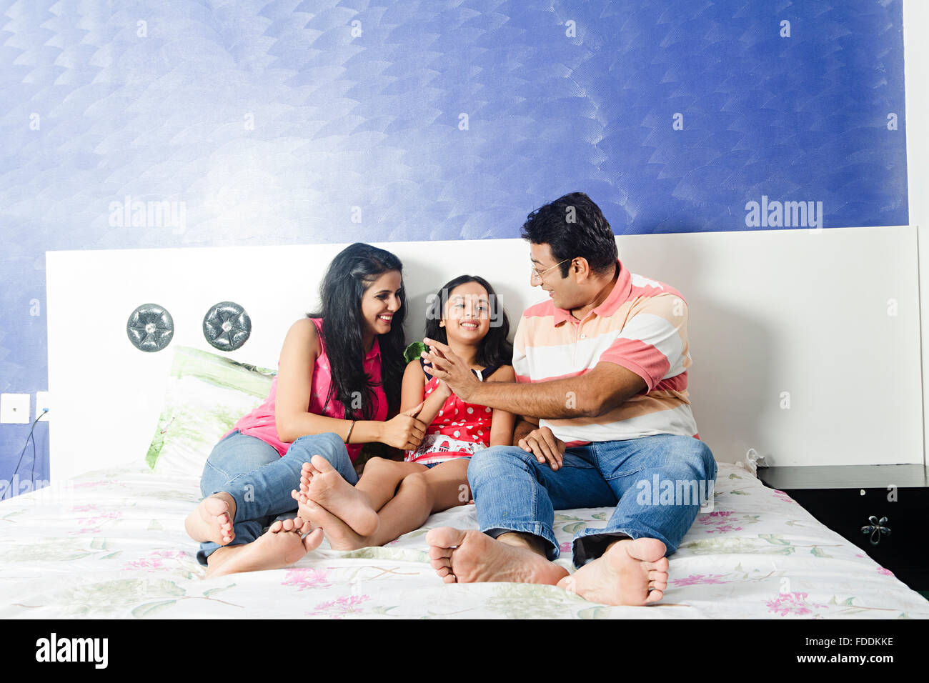 3 People Parents and Kid Daughter Bedroom Sitting Fun Stock Photo