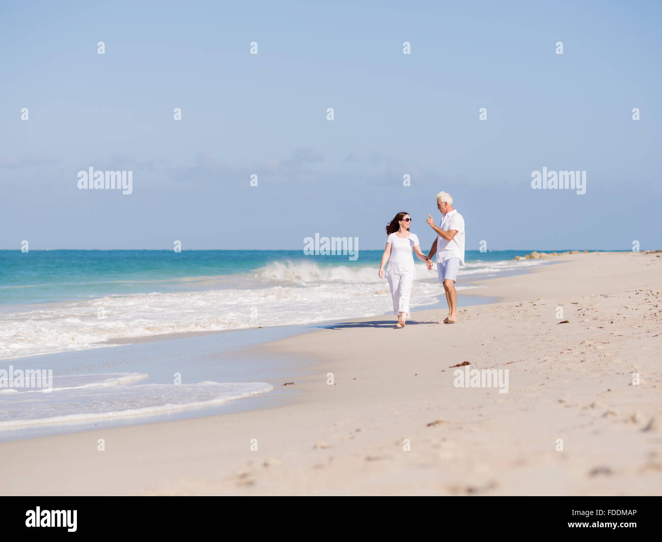 Couple walking on the beach Stock Photo - Alamy
