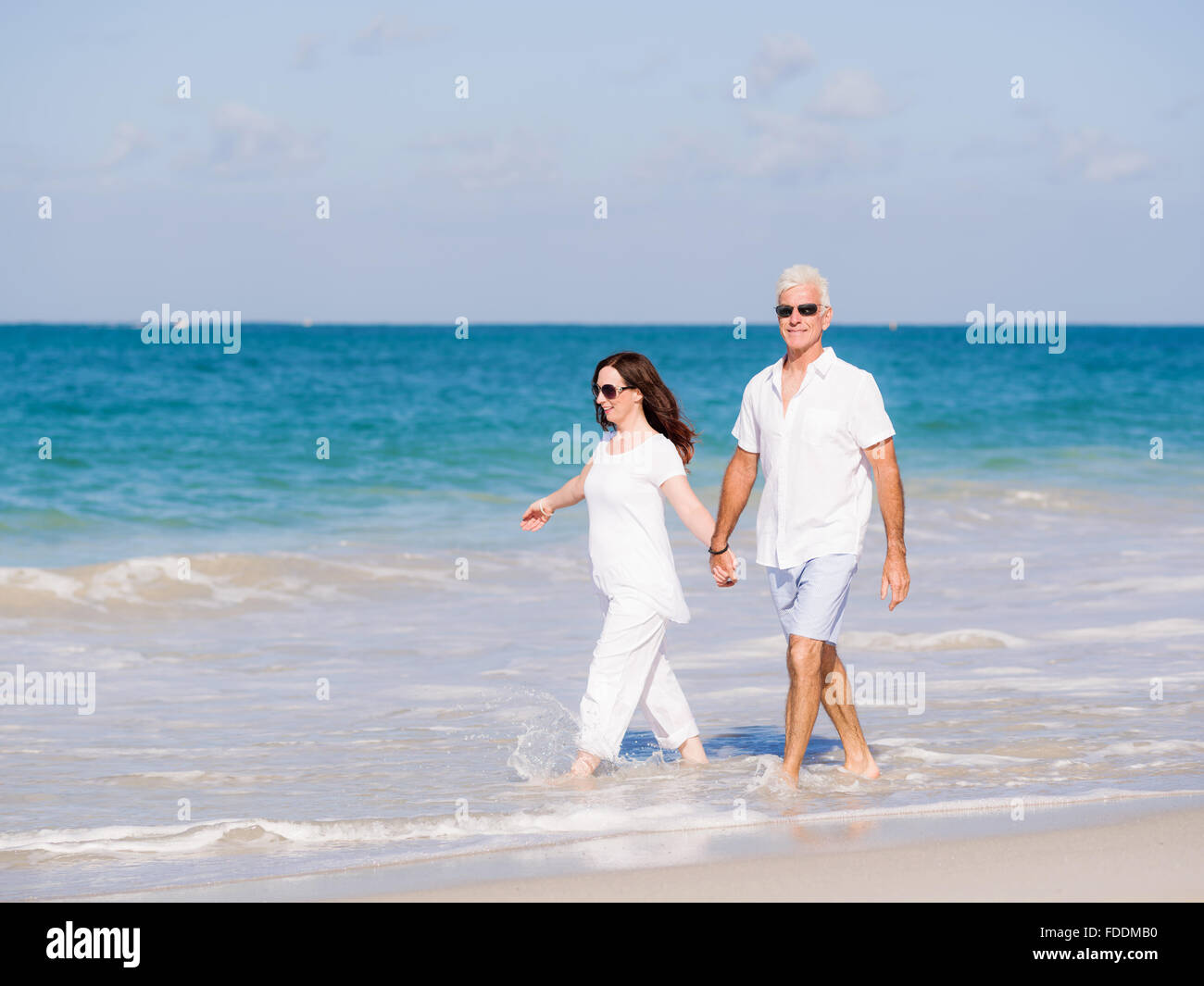 Couple walking on the beach Stock Photo - Alamy