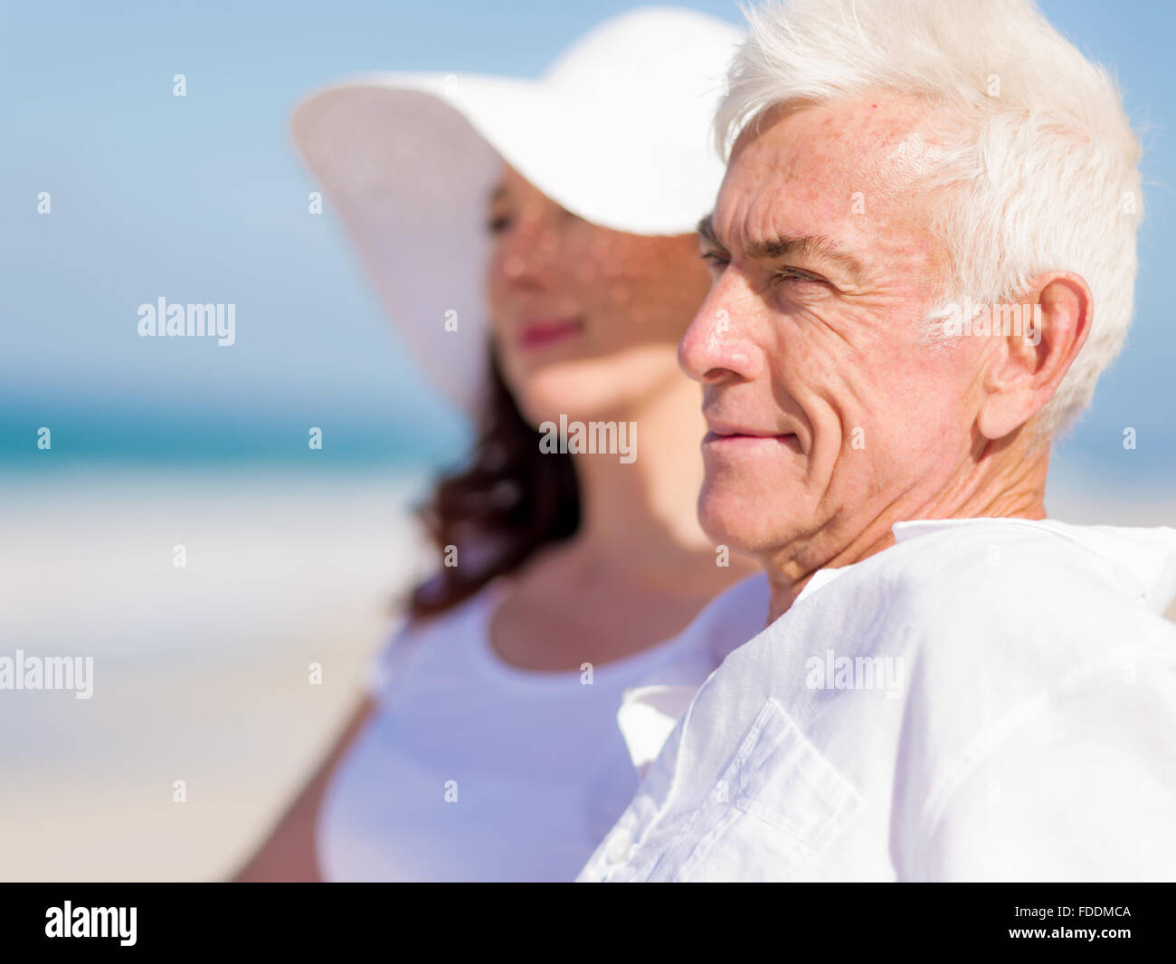 Couple sitting on the beach Stock Photo - Alamy
