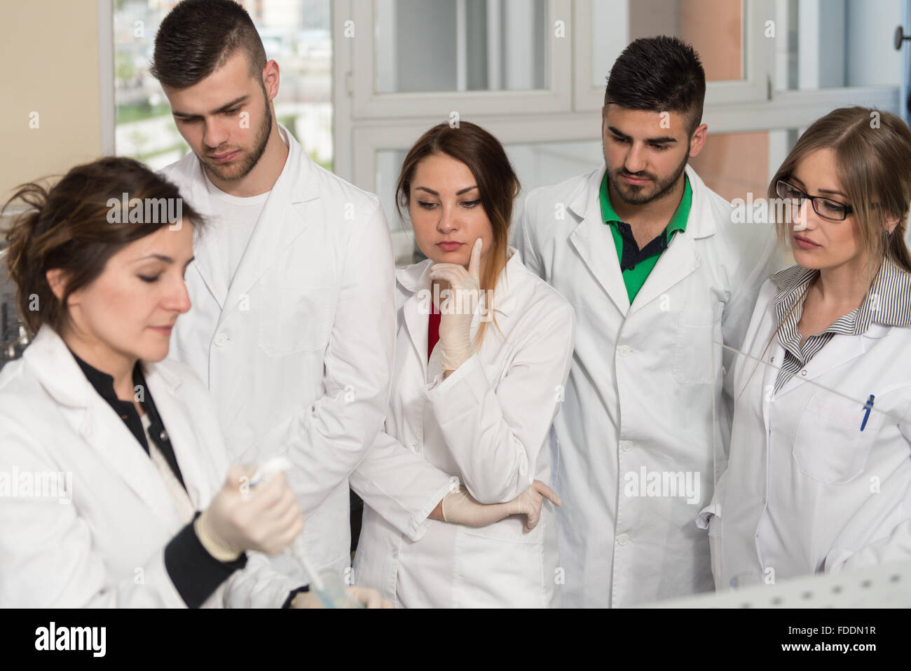 Group Of Students Scientists Conducting Research With Teacher In A Lab Environment Classroom Learning Lessons - Get Help And Sup Stock Photo