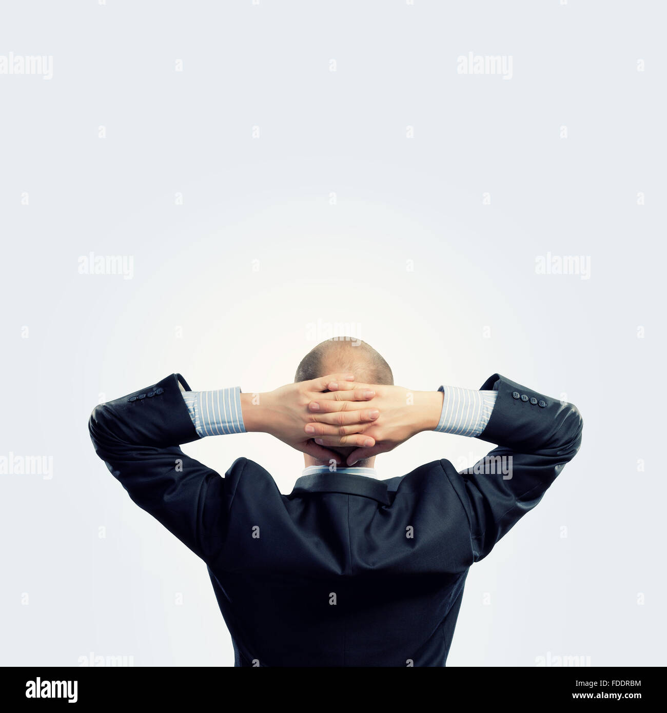 Back view image of businessman with arms crossed behind head. Place for