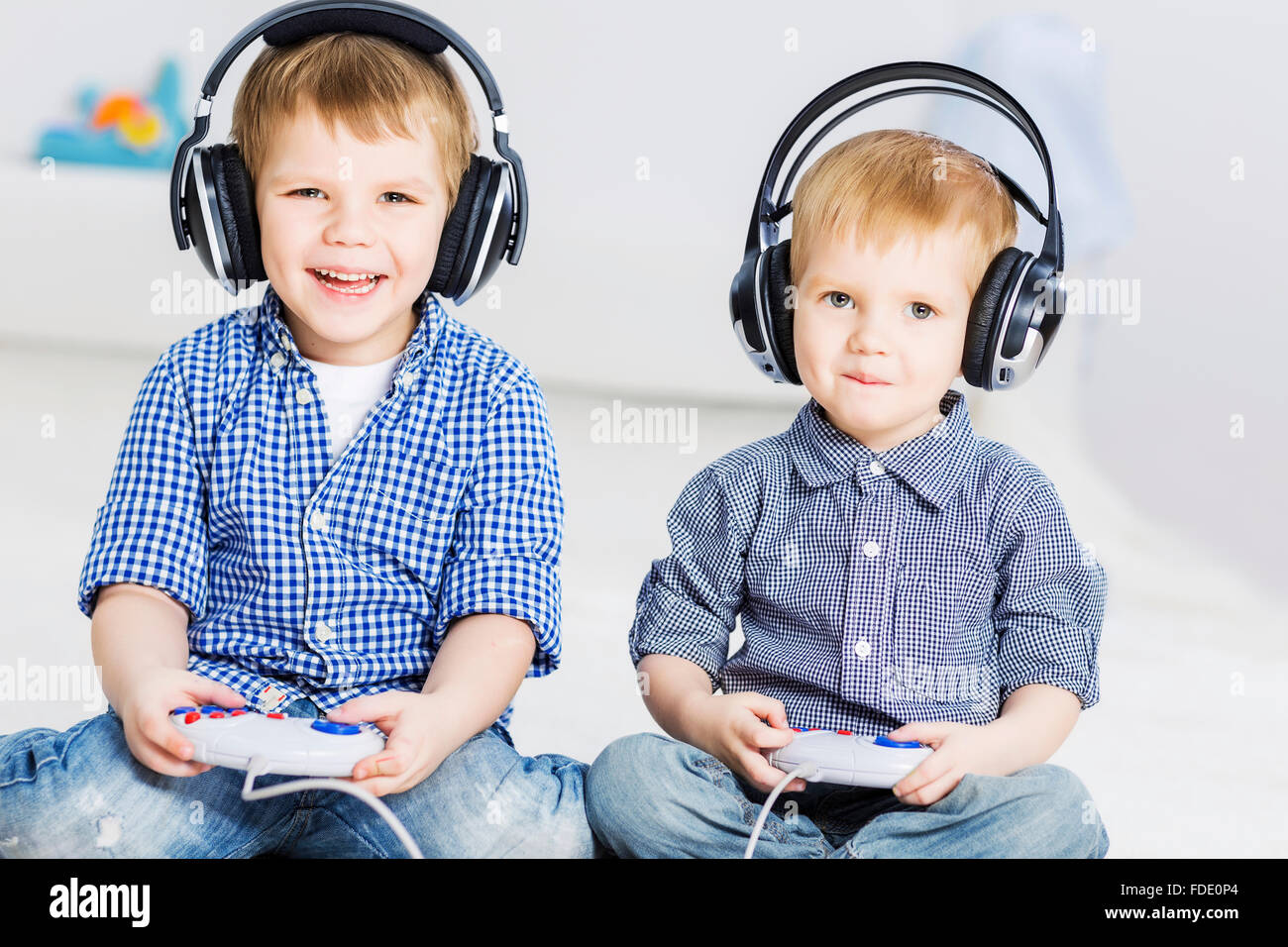 Cute boys playing game in wireless headphones Stock Photo - Alamy