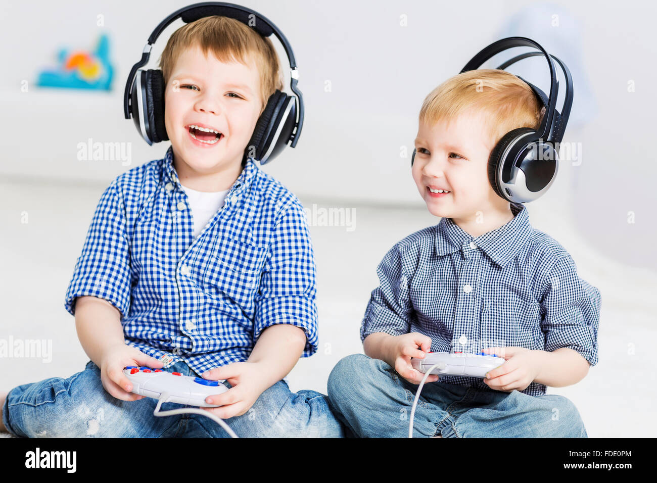 Cute boys playing game in wireless headphones Stock Photo - Alamy