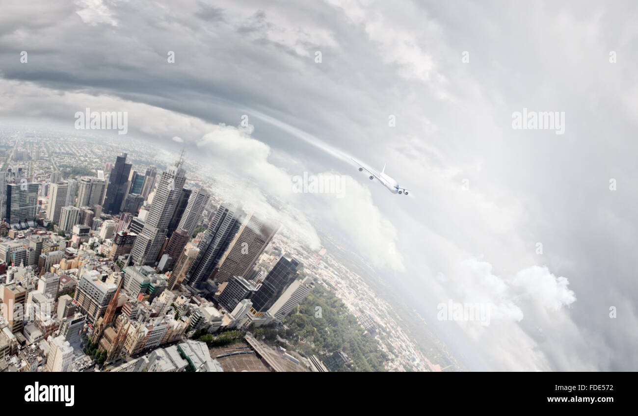 Airplane flying high in sky above city Stock Photo