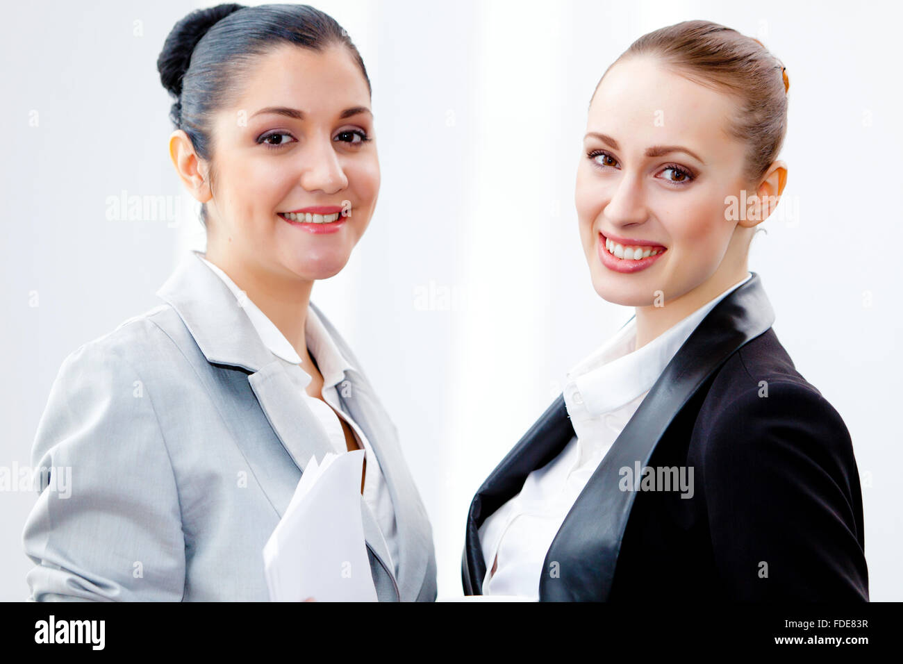 Image of two young pretty businesswomen smiling Stock Photo - Alamy