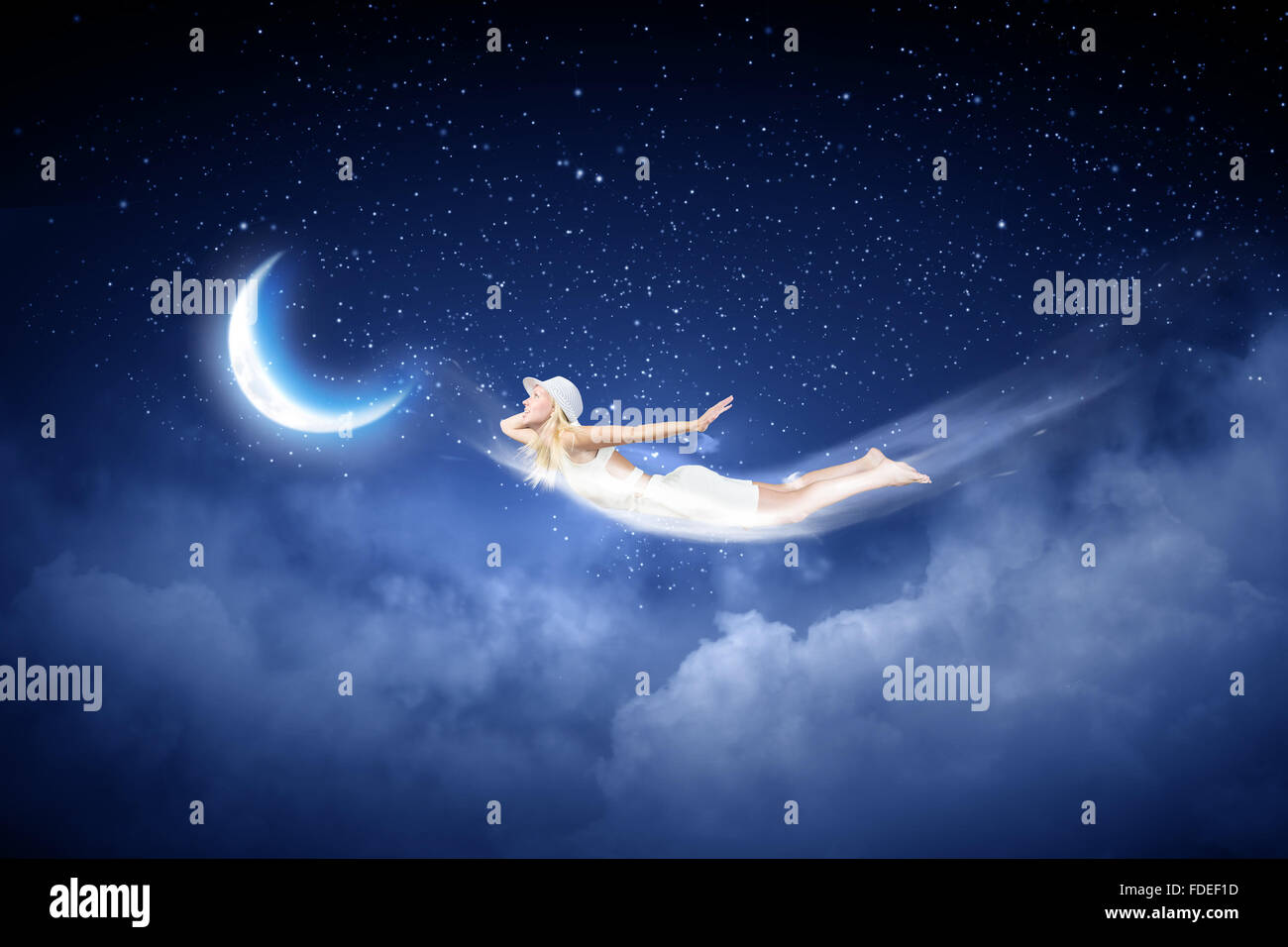 Young blond girl flying in night sky Stock Photo - Alamy