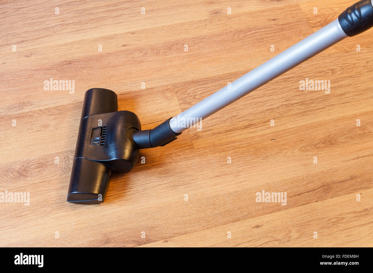 vacuuming of parquet floor by vacuum cleaner at home Stock Photo