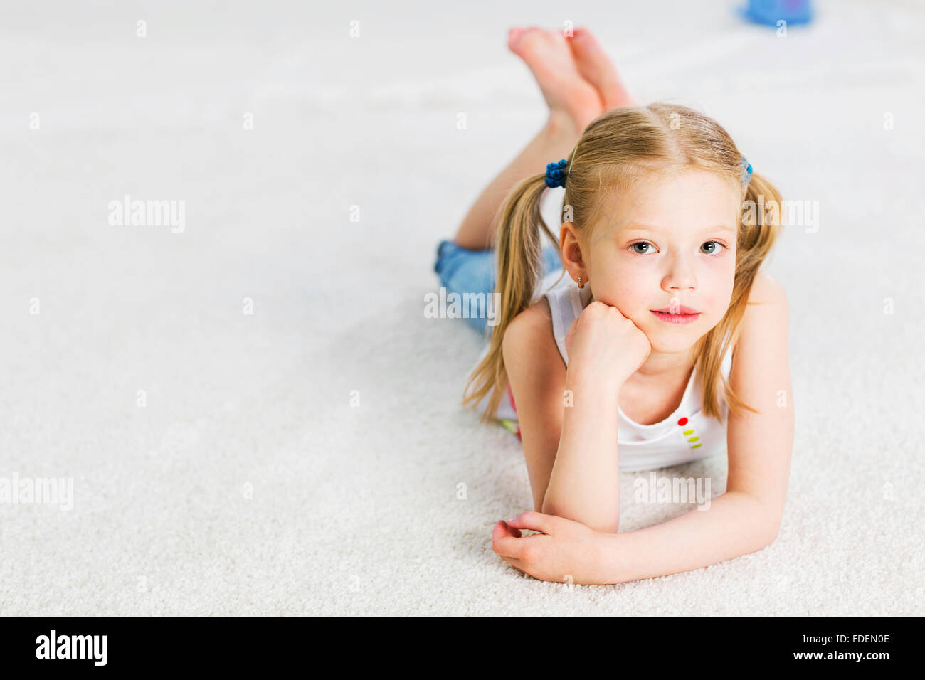 Cute happy girl lying on floor and dreaming Stock Photo - Alamy