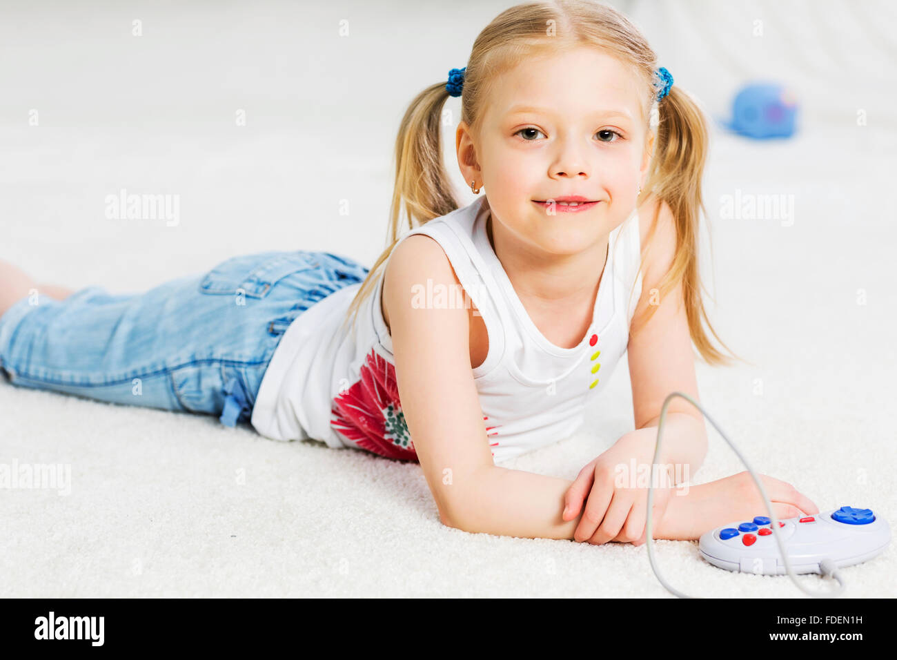 Cute girl lying on floor and playing video game Stock Photo - Alamy