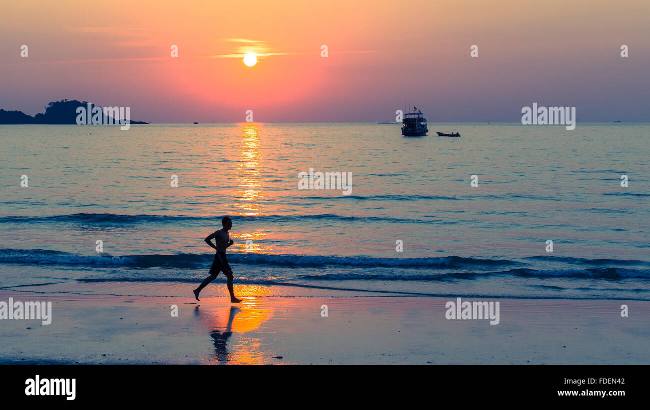 Silhouette of men running on coast line during amazing sunset Stock ...