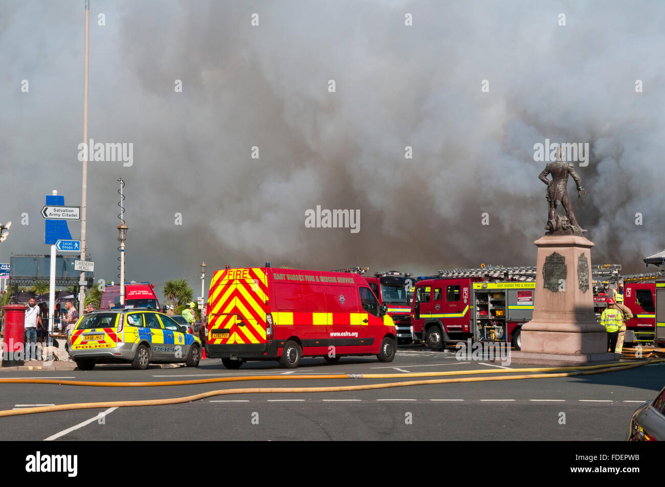 Emergency services attending the fire on Eastbourne Pier with two Coastguard staff in the foreground Stock Photo