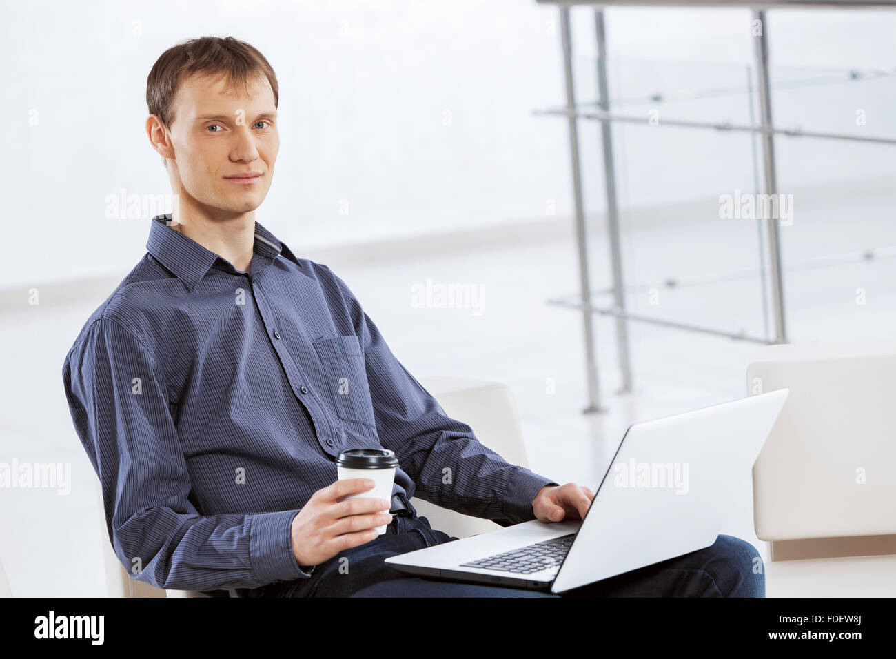 Young handsome businessman sitting and using laptop Stock Photo - Alamy