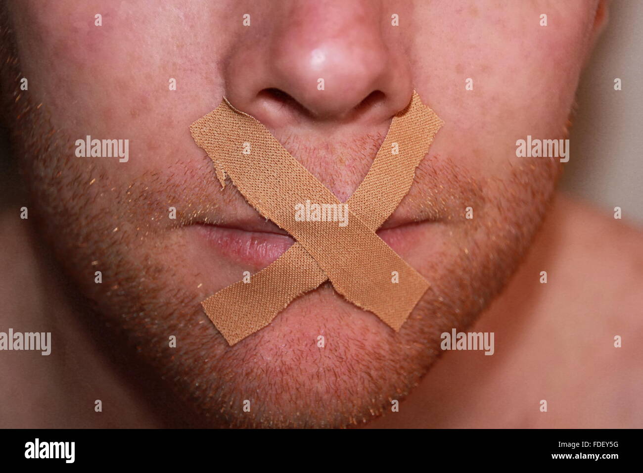 tape covers mouth of a man Stock Photo