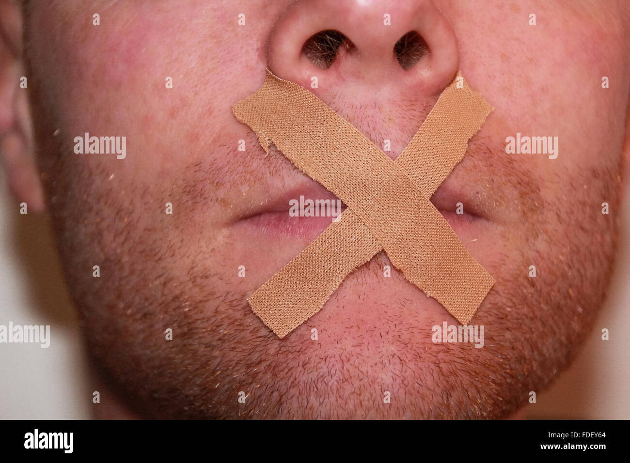 tape covers mouth of a man Stock Photo