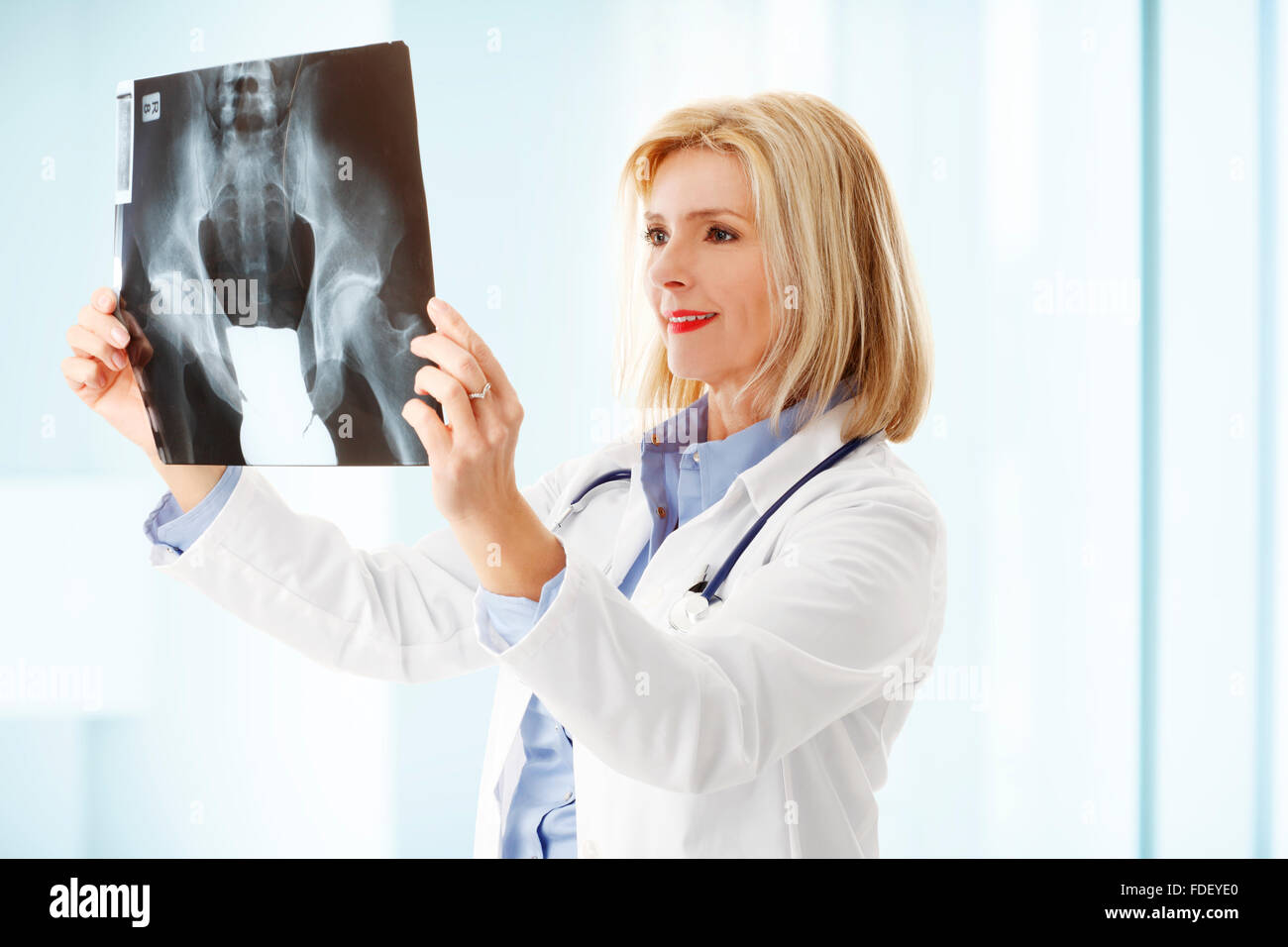 Portrait of xray specialist analyzing xray image while standing at