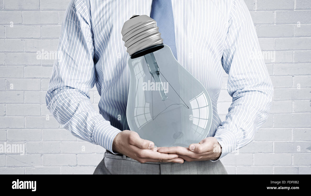 Close up of businessman holding in hands glowing light bulb Stock Photo ...