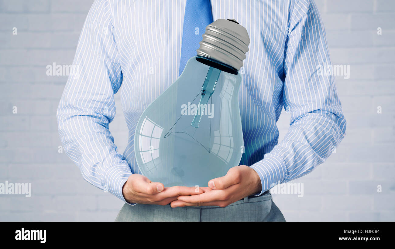 Close up of businessman holding in hands glowing light bulb Stock Photo ...
